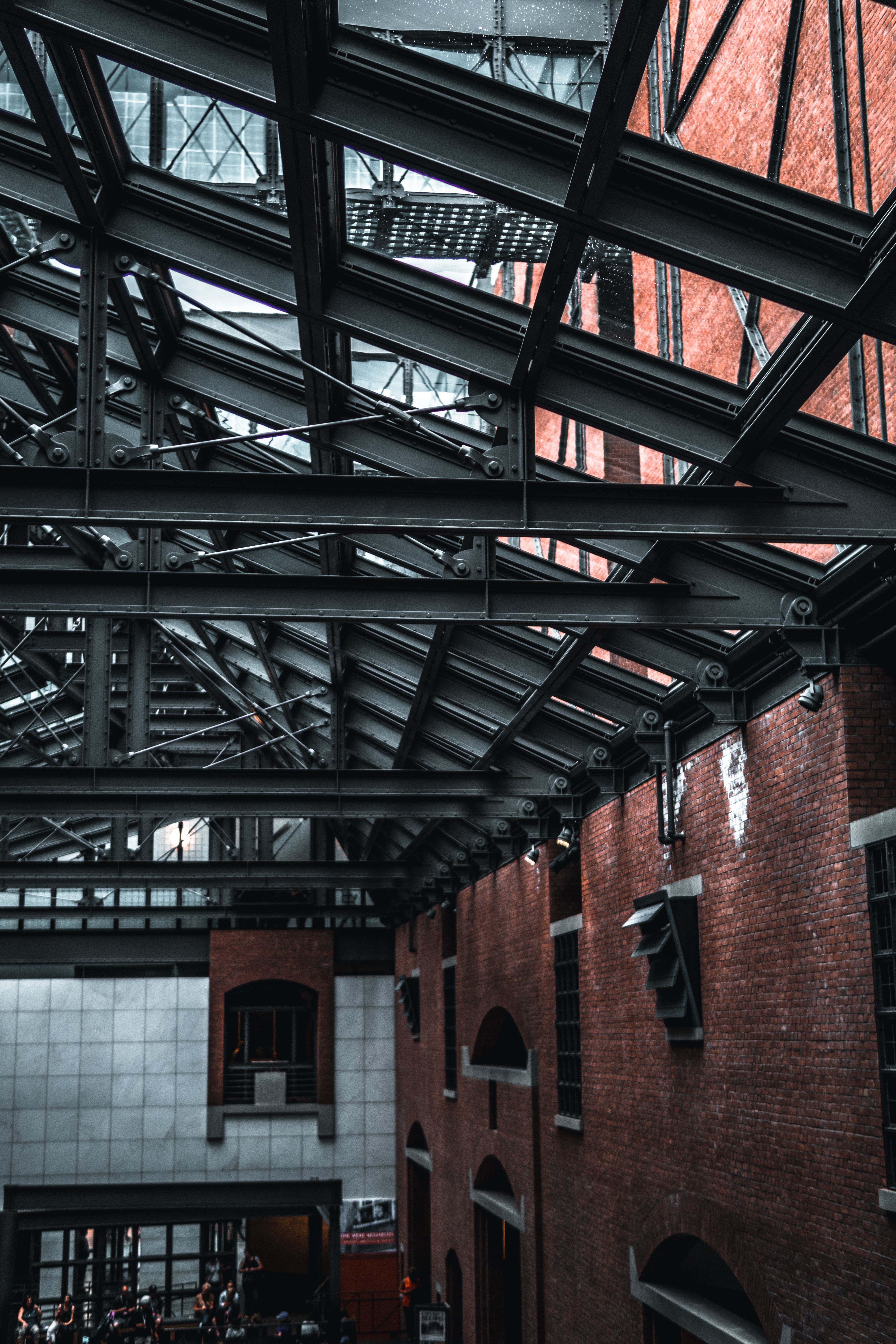 Industrial ceiling detail with exposed steel beams and red brick 